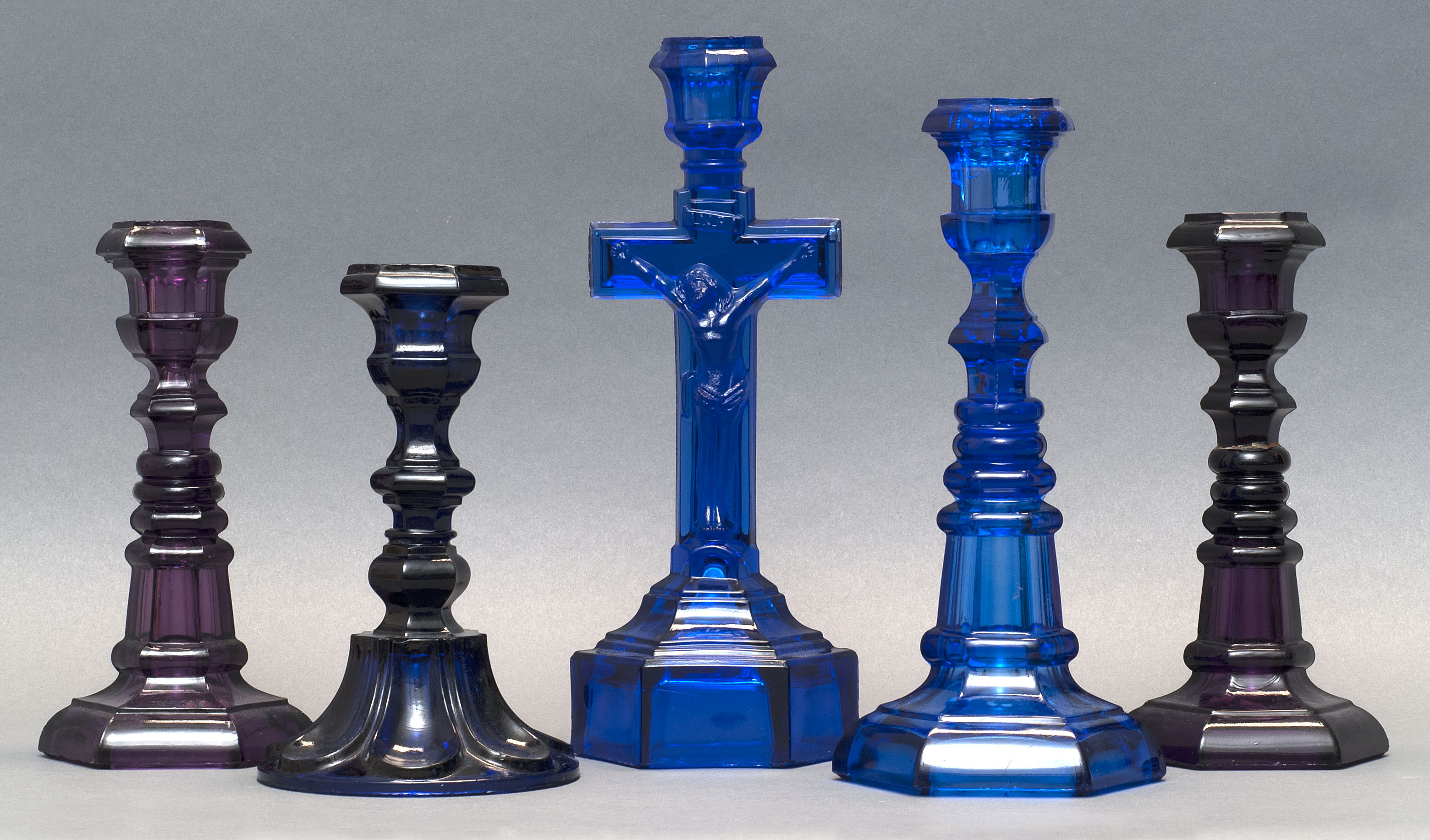 Appraisal: FIVE SANDWICH GLASS COMPANY PRESSED GLASS CANDLESTICKS Mid- th CenturyIn