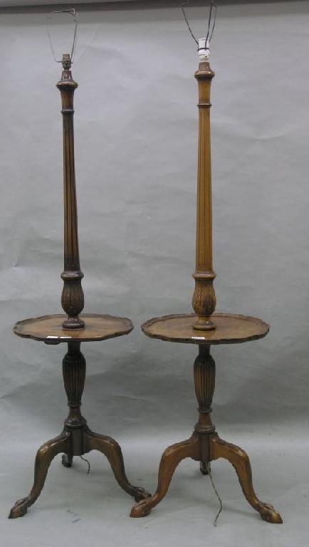 Appraisal: A pair of walnut standard lamps with fluted stems lobed