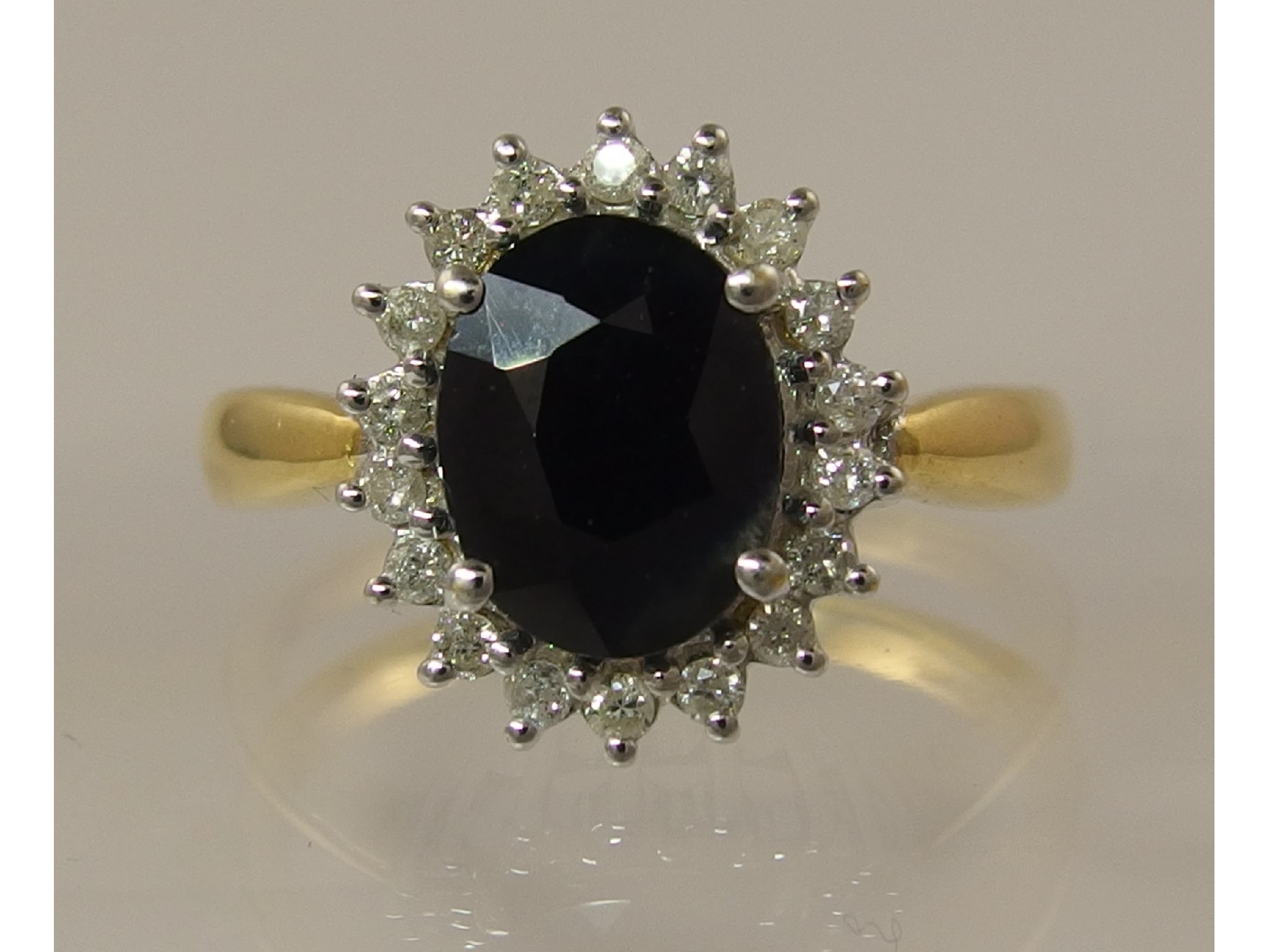 Appraisal: An ct sapphire and diamond cluster ringthe oval facet cut