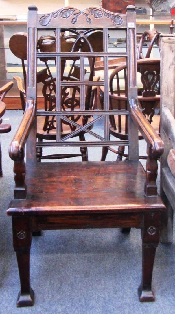 Appraisal: A th century carved oak open armchair on block supports