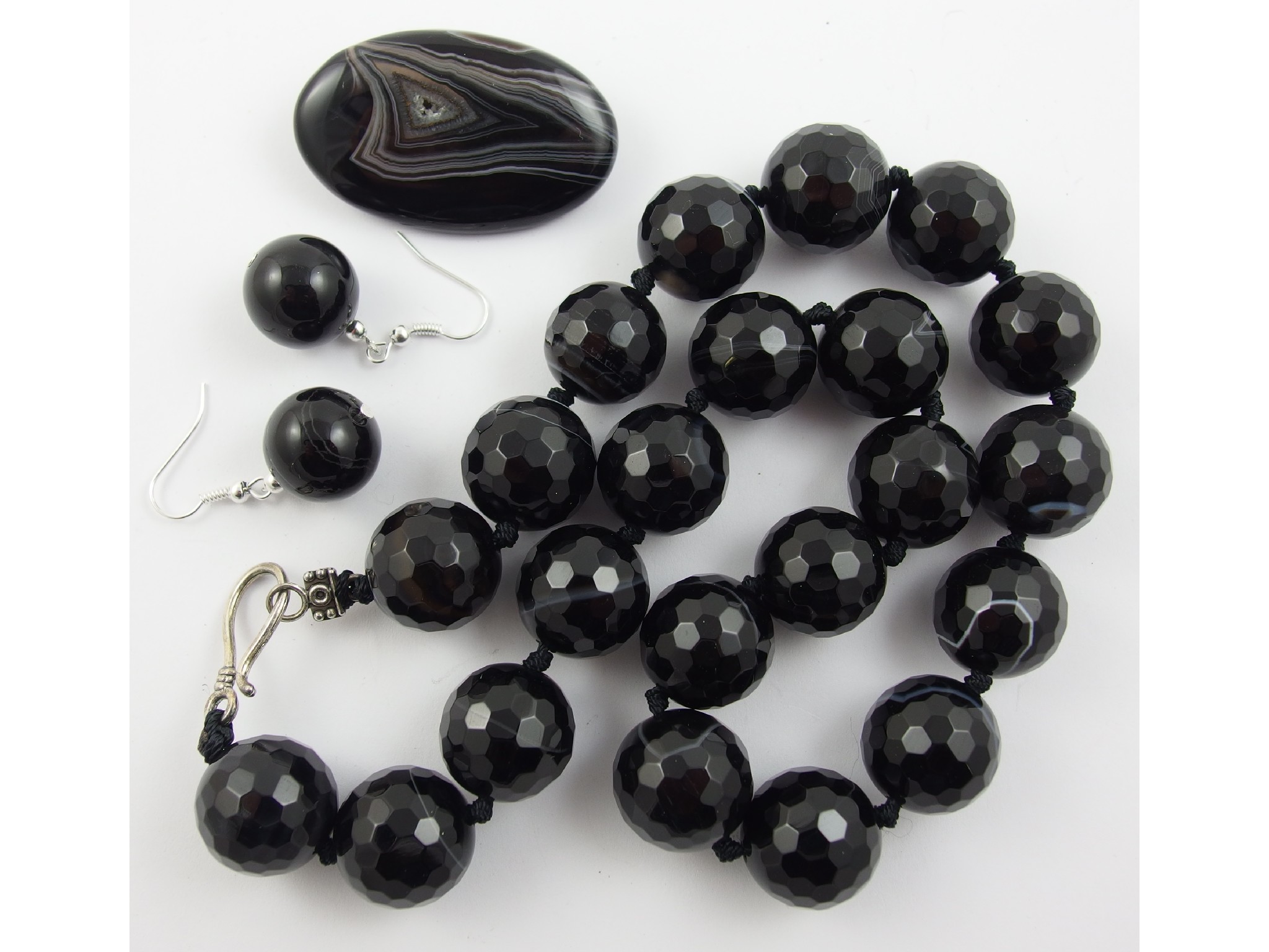 Appraisal: A string of banded agate faceted beads with similar earrings