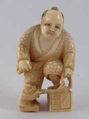 Appraisal: A Japanese ivory netsuke of a man in elaborate robe