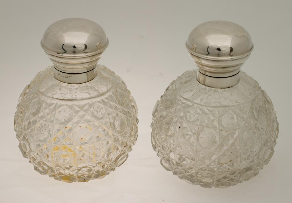 Appraisal: PAIR OF EDWARDIAN SILVER-TOPPED AND CUT-GLASS PERFUMES with globular hob-nail