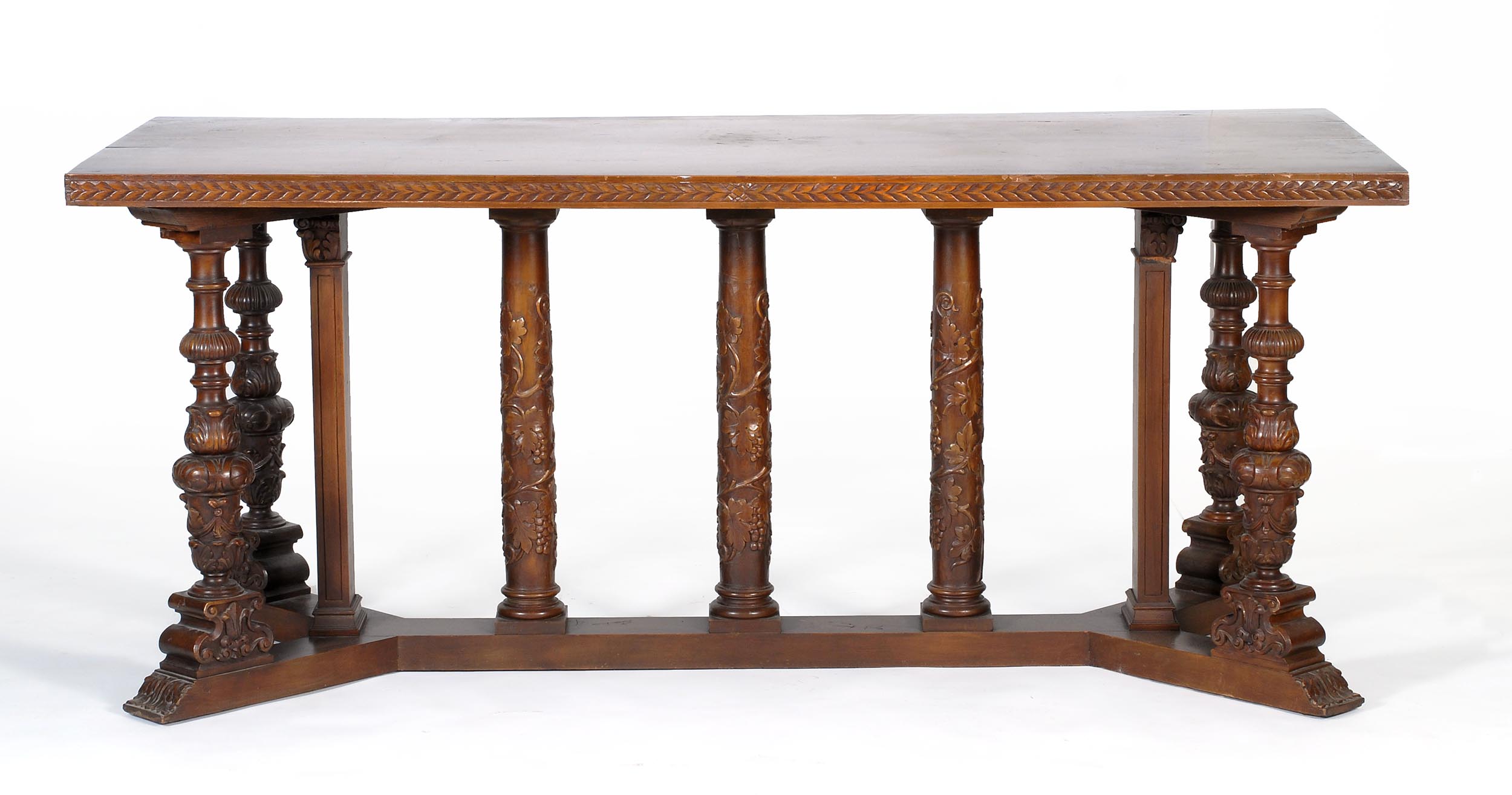 Appraisal: MODERN TRESTLE TABLE in walnut With carved edges and Gothic-style