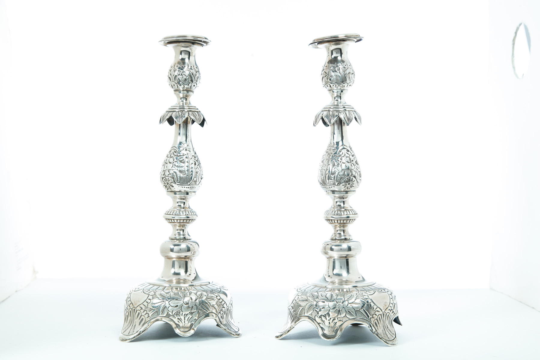 Appraisal: PAIR OF RUSSIAN SILVER CANDLESTICKS Nineteenth century Chased floral designs