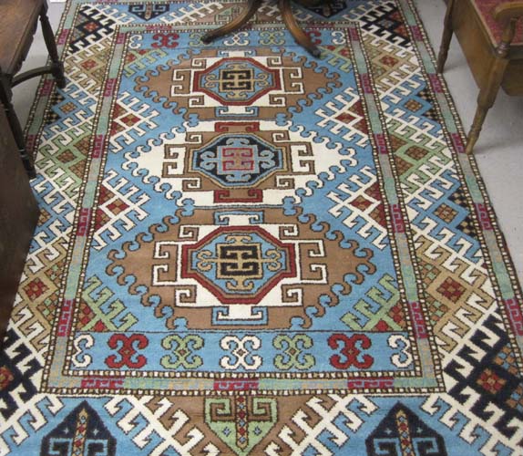 Appraisal: HAND KNOTTED ORIENTAL CARPET Indo-Kazak three geometric medallion design on