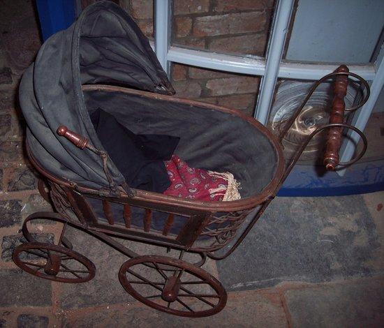 Appraisal: A child's toy pram with concertina hood and wicker frame