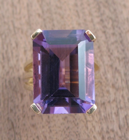 Appraisal: AMETHYST AND FOURTEEN KARAT GOLD RING centering a single emerald-cut