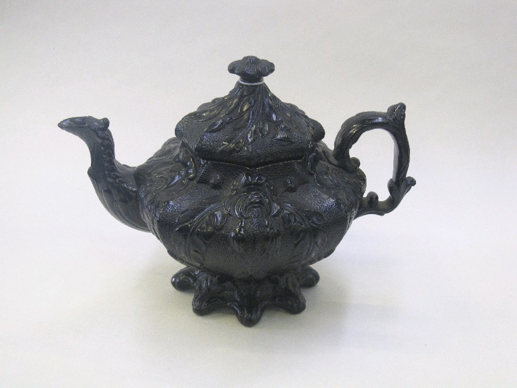 Appraisal: Black pottery teapot relief moulded with flowers and an oriental