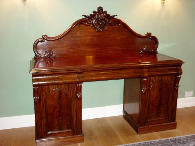 Appraisal: A Victorian mahogany pedestal sideboard with scroll carved surmount to