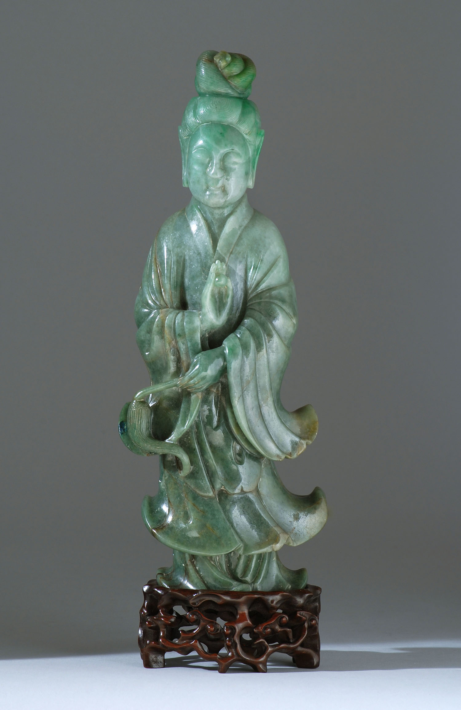 Appraisal: GREEN JADEITE FIGURE Late th CenturyIn the form of Guanyin