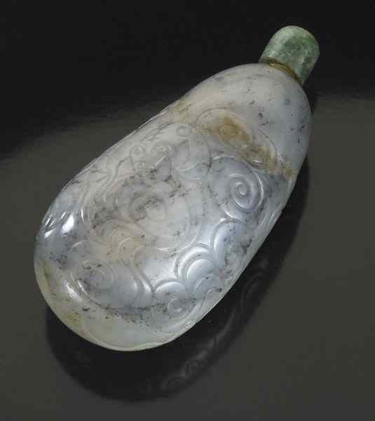 Appraisal: Chinese Qing carved black and white pebble jadesnuff bottle depicting