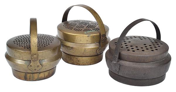 Appraisal: THREE INDIAN BRASS HAND WARMERS each with a pierced cover