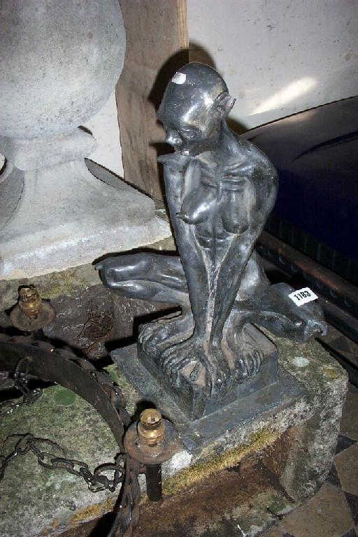 Appraisal: A heavy lead statue of a seated grotesque figure -