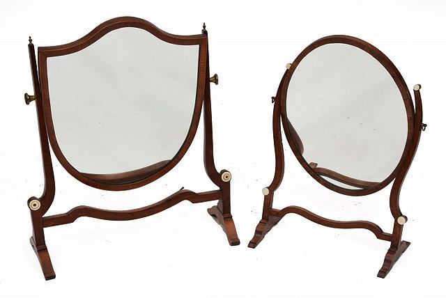 Appraisal: A MAHOGANY OVAL DRESSING MIRROR with shaped supports and ivory