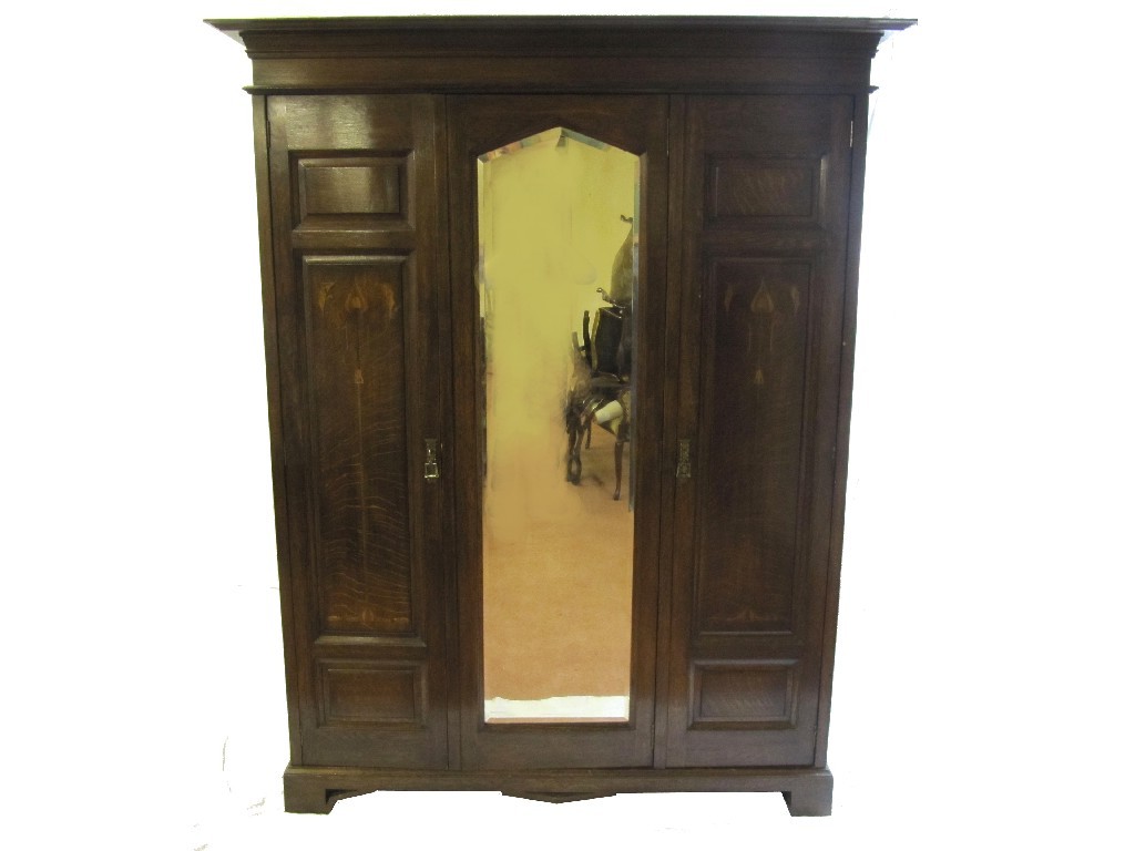 Appraisal: An Art Nouveau oak mirrored triple door wardrobe bearing inlaid