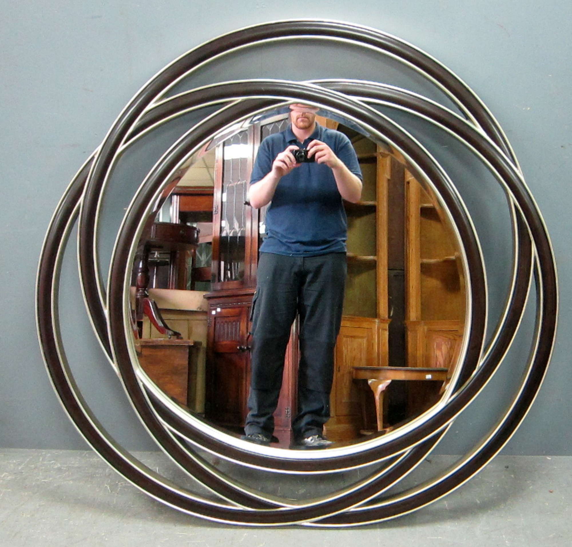 Appraisal: R V Astley circular mirror with stylised pierced wooden frame