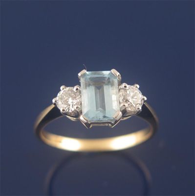 Appraisal: An aquamarine and diamond three stone ring the emerald cut