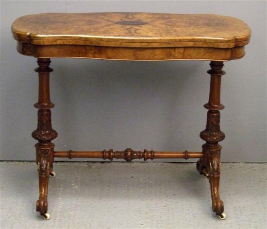 Appraisal: Victorian walnut serpentine folding card table on turned twin end