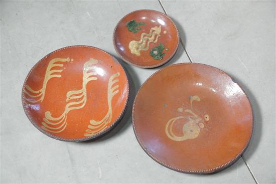 Appraisal: THREE REDWARE SLIP DECORATED PLATES Each with coggled rims One