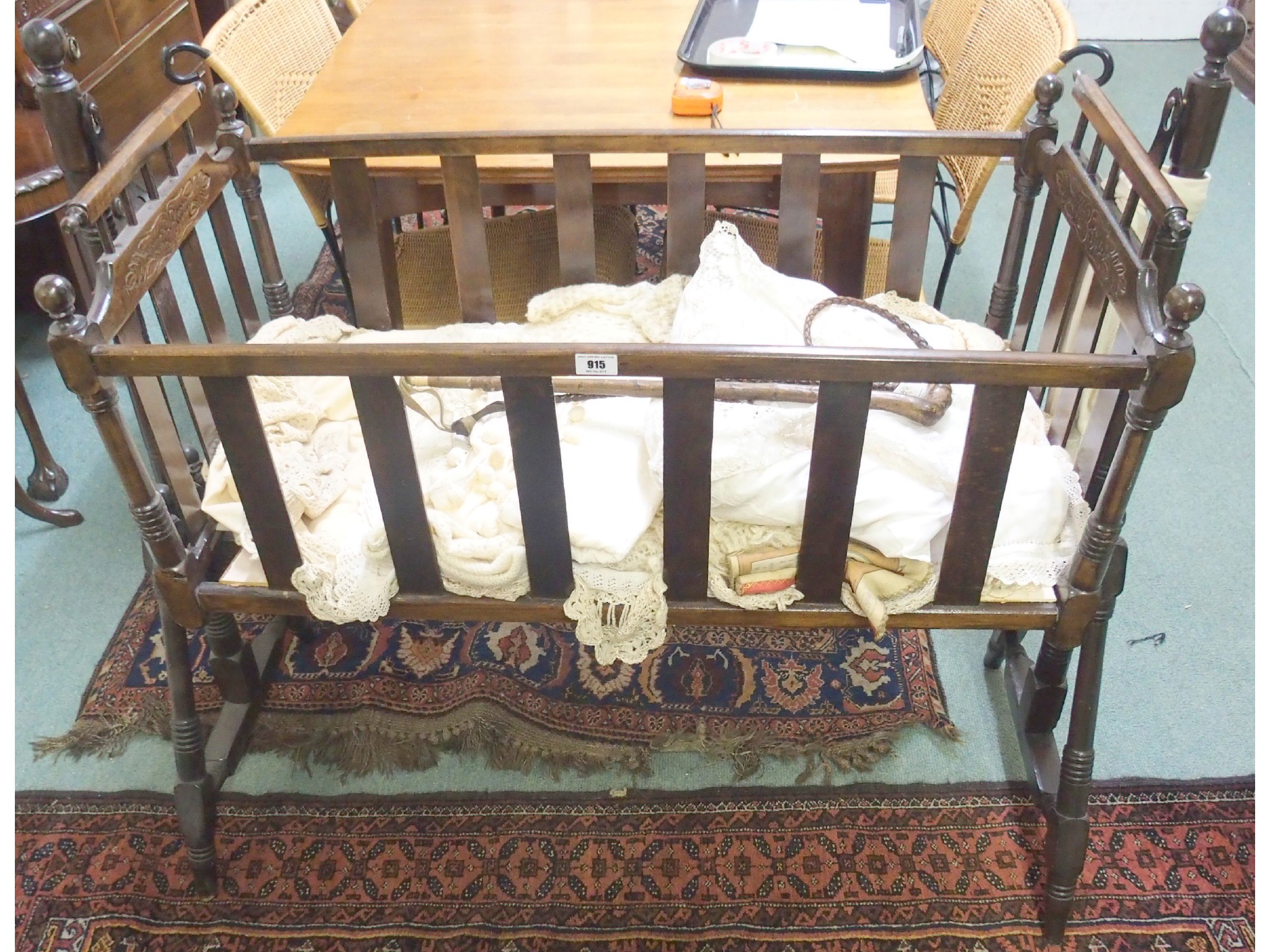 Appraisal: A Victorian wooden swinging crib with bedding