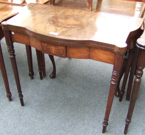 Appraisal: A mahogany fold over card table the shaped inlaid top