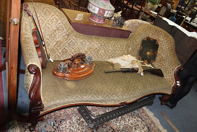 Appraisal: A VICTORIAN MAHOGANY SOFA with button upholstered shaped back carved