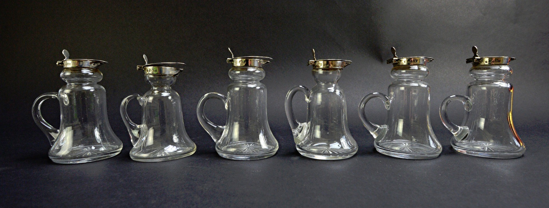 Appraisal: Six similar silver mounted glass whiskey flasks of slender waisted