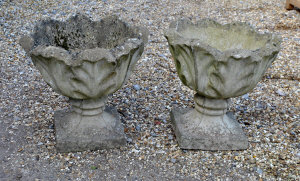 Appraisal: Pair of cast stone weathered garden urns on square plinth