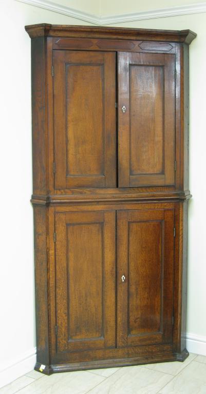 Appraisal: A Georgian oak Double Corner Cupboard with two pairs of