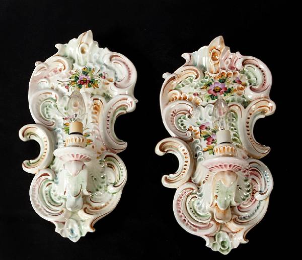 Appraisal: A pair of Italian glazed earthenware wall sconces electrified height