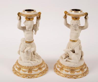 Appraisal: A pair of glazed and biscuit porcelain figural candlesticks the