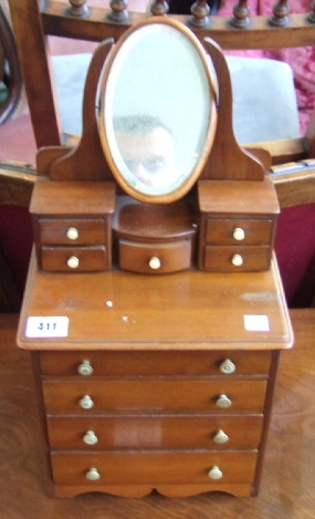 Appraisal: A miniature dressing table the bevelled oval mirror over four