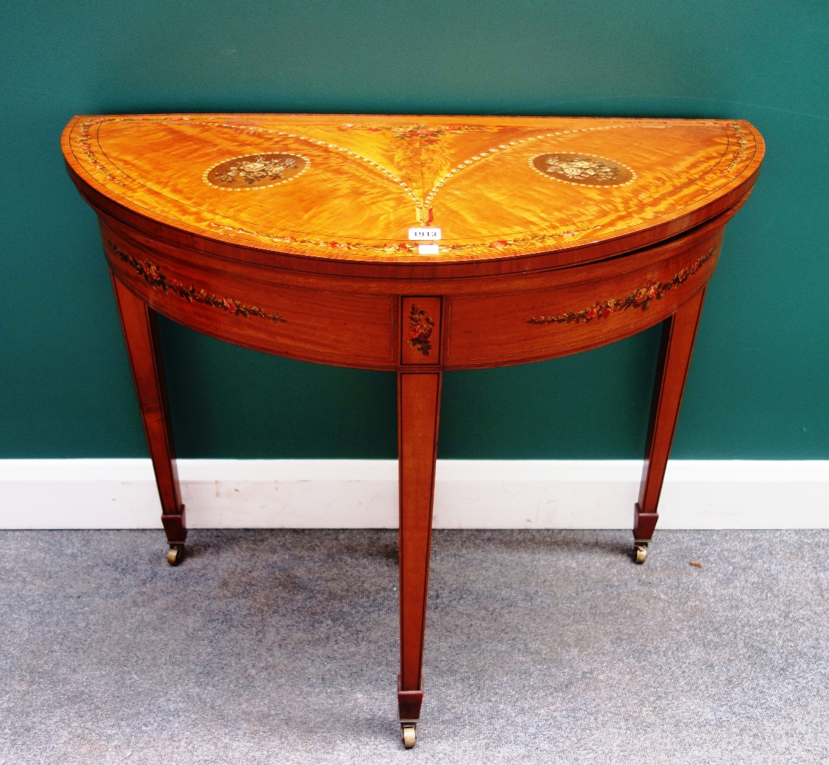 Appraisal: A late th century floral painted satinwood card table on