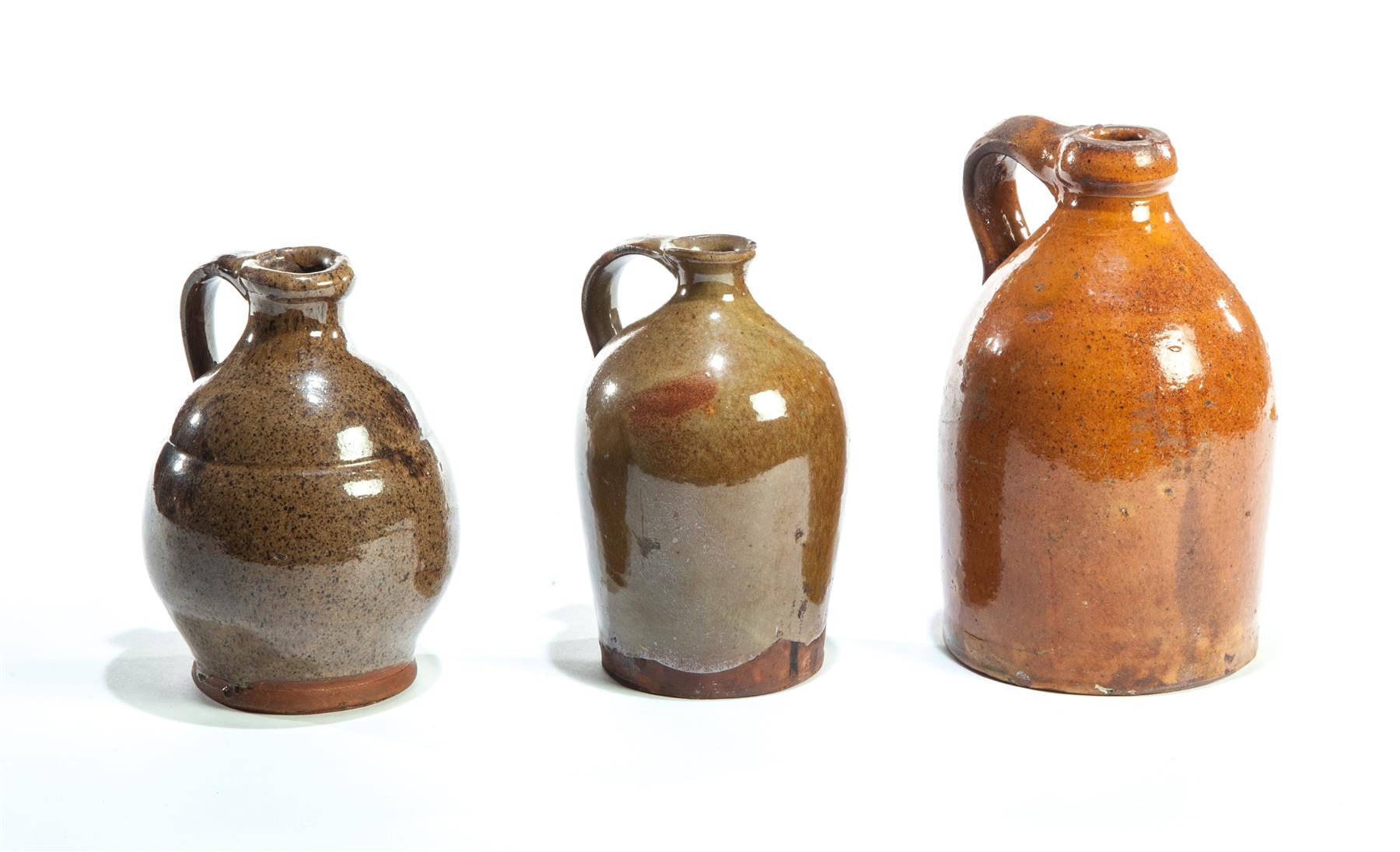 Appraisal: THREE NEW ENGLAND REDWARE JUGS First half- th century Diminutive