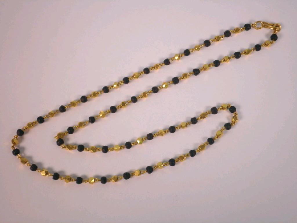 Appraisal: A yellow metal and black bead necklace marked weight all