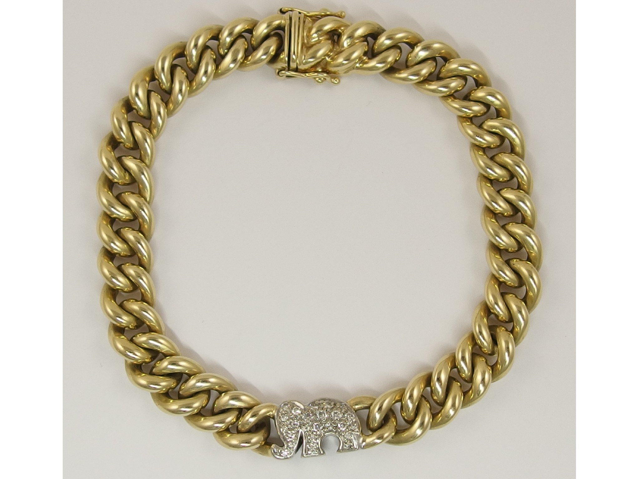 Appraisal: A ct curb chain bracelet with a diamond set elephant