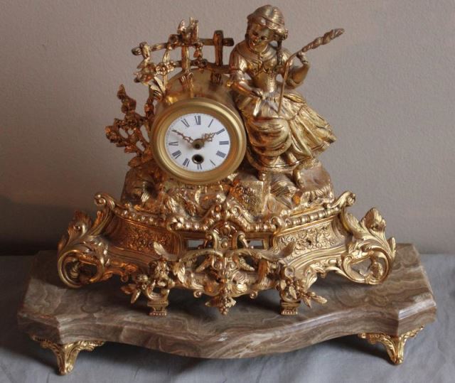 Appraisal: Gilt Metal Figural Clock with Enamel Face From a West