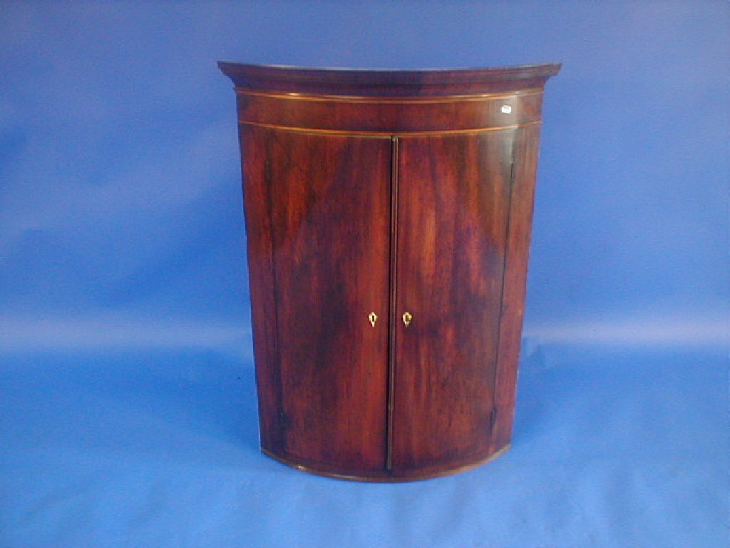 Appraisal: A George III mahogany cylinder fronted hanging corner cupboard with