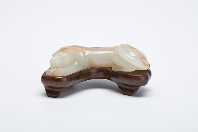 Appraisal: A CHINESE RUSSET WHITE JADE RECUMBENT HOUND its head resting