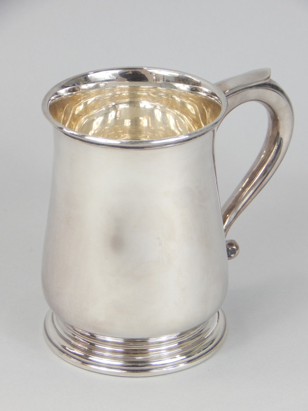 Appraisal: A modern silver baluster shaped mug with a scroll handle