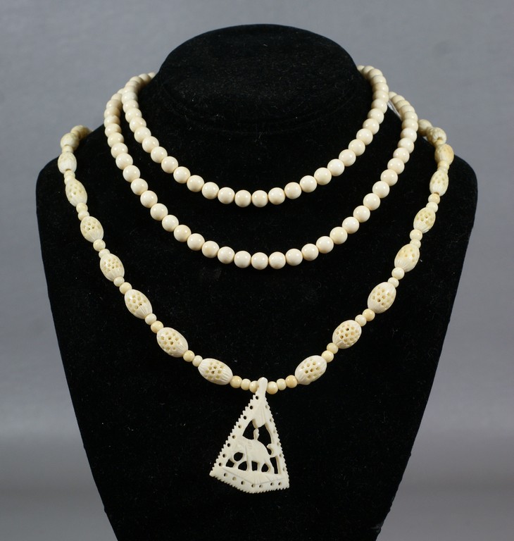 Appraisal: Ivory necklaces one plain beads long one carved with elephant