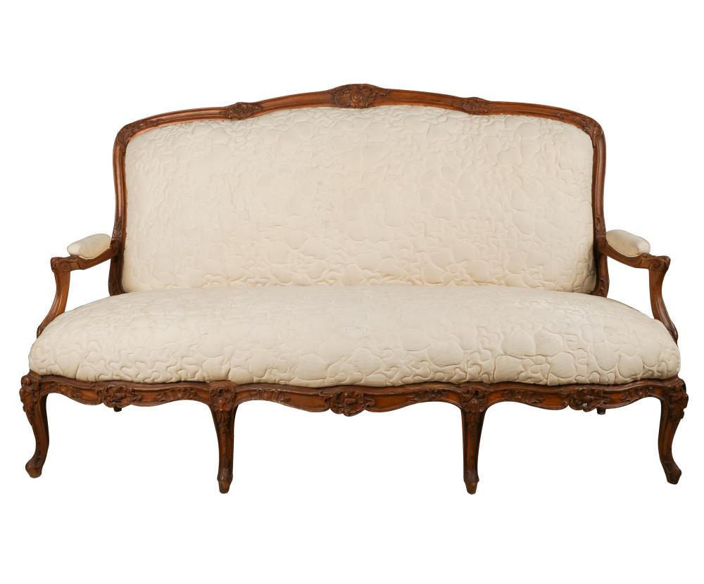 Appraisal: LOUIS XV PROVINCIAL-STYLE CARVED WALNUT SETTEEcovered with cream-colored quilted fabric