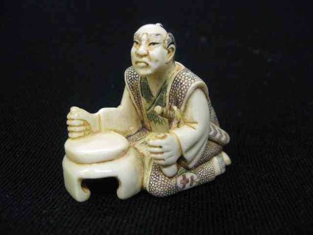 Appraisal: Carved Ivory Netsuke of Samurai Warriorseated at table fancy polychrome