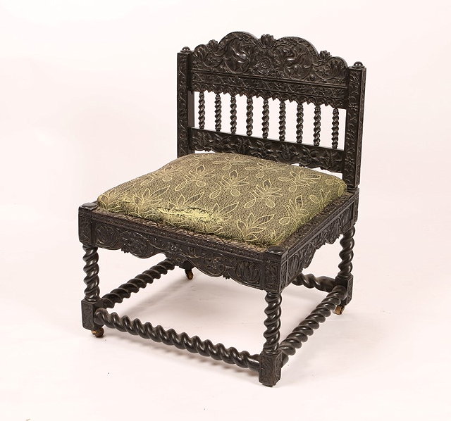 Appraisal: A BATAVIAN CARVED EBONY LOW OCCASIONAL CHAIR with stylised foliate