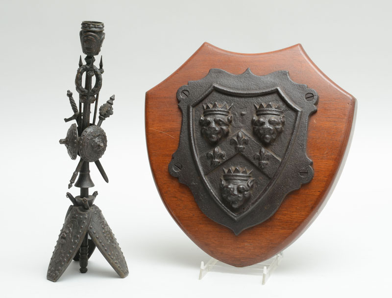 Appraisal: CONTINENTAL CAST-IRON SHIELD AND A BRONZE TRIPOD CANDLESTICK The one