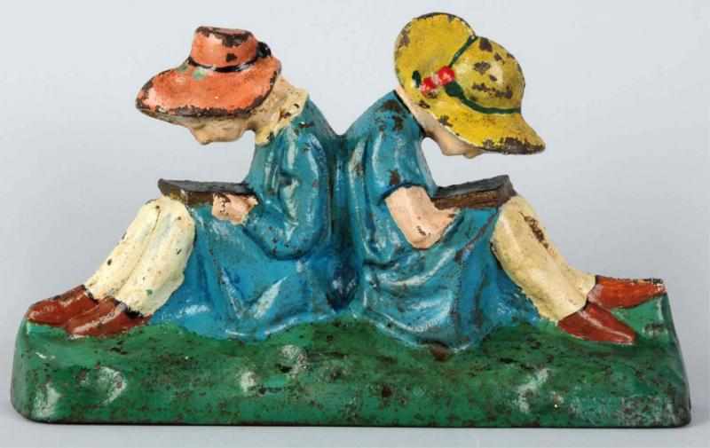 Appraisal: Cast Iron Girls Reading Books Doorstop Depicts two girls sitting