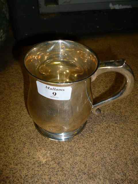 Appraisal: A SILVER TANKARD of baluster form with scrolling looped handle