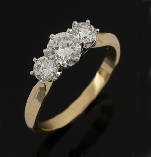 Appraisal: A three stone diamond ring Centrally set with a round