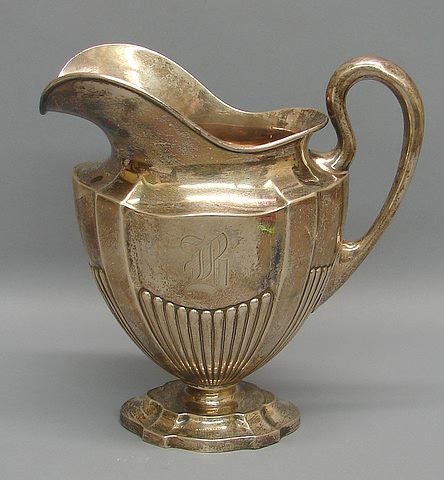 Appraisal: Helmet-form spout oval in section with reeded decoration shield-form base